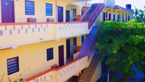 A multi-story building with a staircase connecting the floors. - Hotel Le Meridien (Les Cayes)