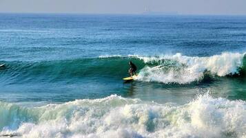 Une plage avec des vagues et un surfeur.