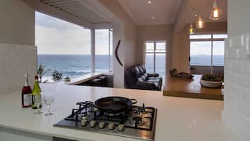 Departamento superior, 2 habitaciones, vista al océano, frente al mar | Área de sala de estar | Smart TV de 50 pulgadas con canales vía satélite, televisión y Netflix