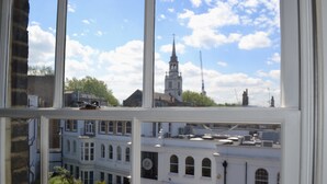 Blick durch ein Fenster auf ein Gebäude mit einem Kirchturm und einer Kirche im Hintergrund.