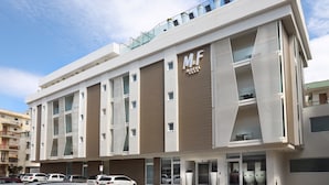 A modern M&F Hotel building with a flat facade, large windows, and a rooftop garden. - M&F Hotel (Gallipoli)