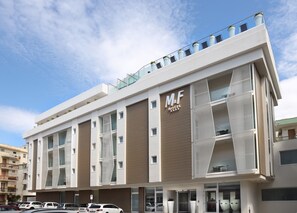 A modern M&F Hotel building with a flat facade, large windows, and a rooftop garden. - M&F Hotel (Gallipoli)