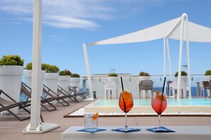 A poolside area with lounge chairs and a table with drinks. - M&F Hotel (Gallipoli)