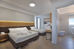 A hotel room with a large bed, bedside tables, a bathroom, and a shower area.