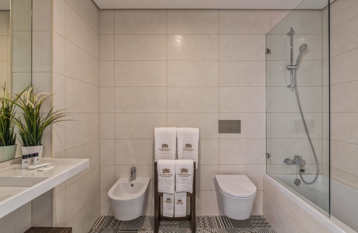 A modern bathroom with a glass-enclosed shower, a bidet, a toilet, and a vanity with a sink.