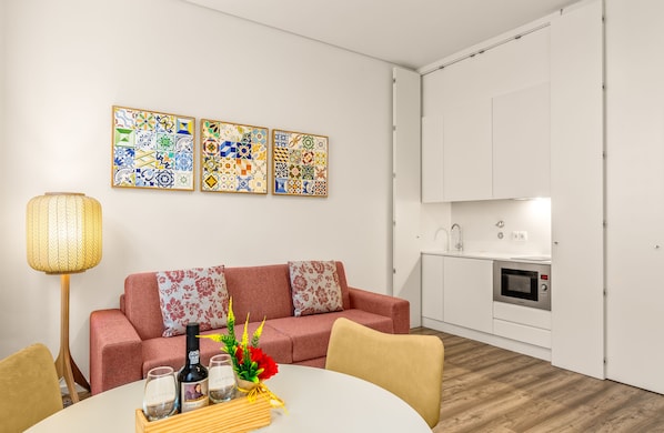 Una sala moderna con un sofá, una mesa de comedor y una zona de cocina.