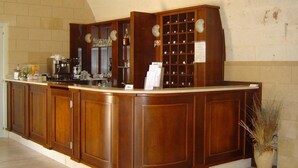 Een houten bar met een toonbank, planken en een bloempot.