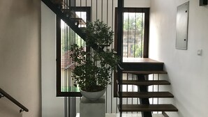 Eine Treppe mit einem Blumentopf, einem Metallgeländer und einer Tür mit Fenster.