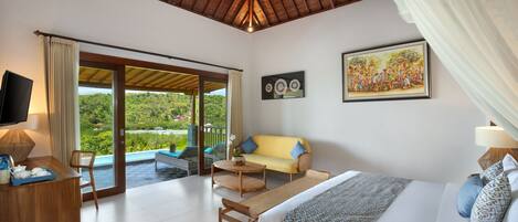 A spacious room with a bed, a sofa, a TV, and a dining area.