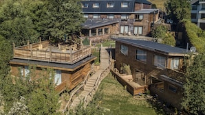 Een modern meerlaags gebouw met houten terrassen en grote ramen.