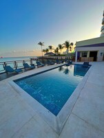 Una piscina al aire libre, sillones reclinables de piscina