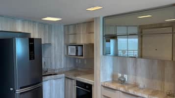 Cozinha moderna com eletrodomésticos embutidos, micro-ondas e lava-louças.