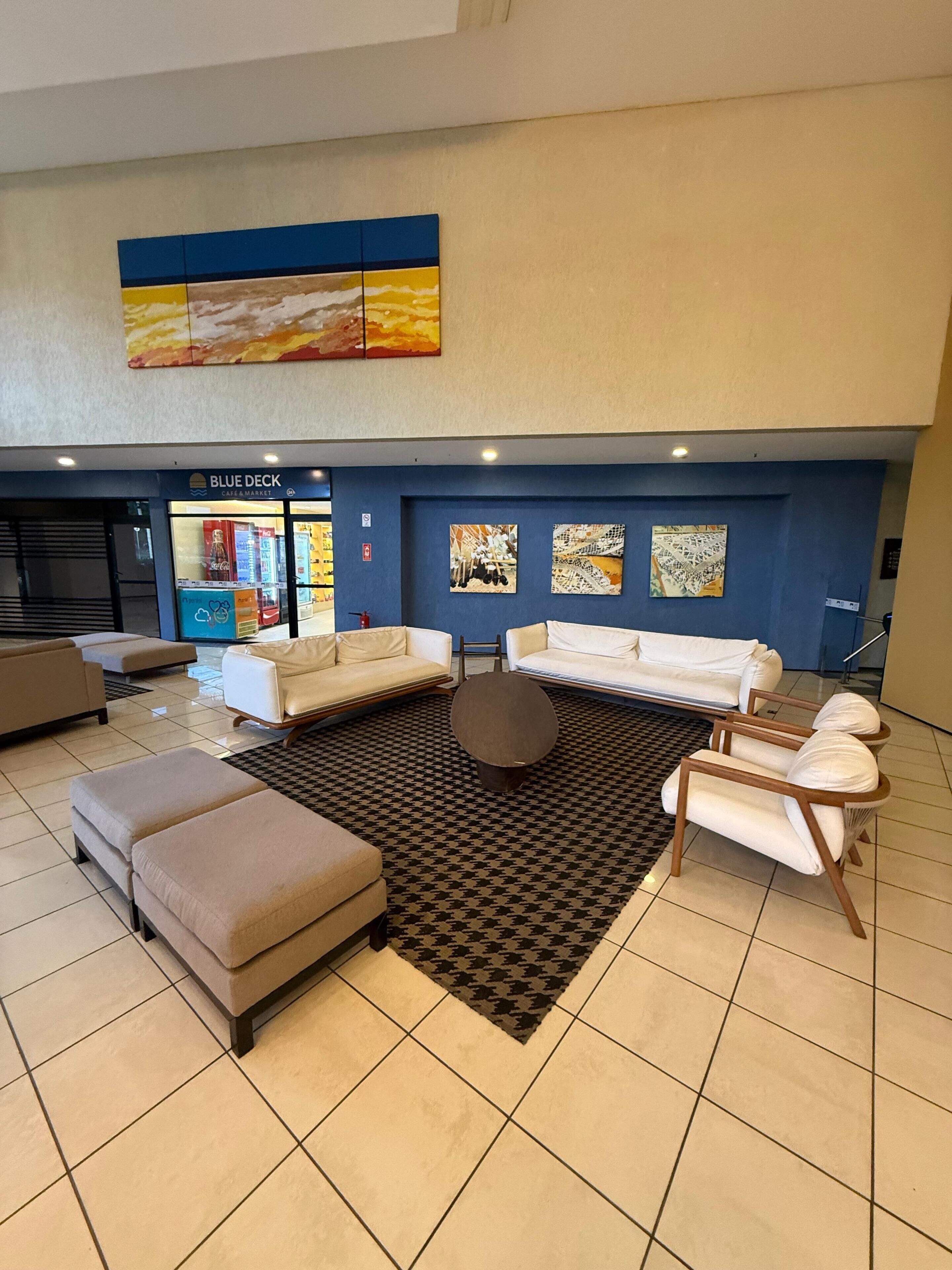 A modern living room with a sectional sofa, ottomans, a round coffee table, and a patterned rug.