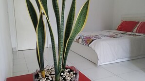 A bedroom with a bed, a potted plant, and a white tiled floor. - Family Suite DESA TEBRAU JOHOR BAHRU (Johor Bahru)