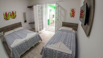 Ett hotellrum med två sängar, en tv och ett badrum som syns genom en öppen dörr.