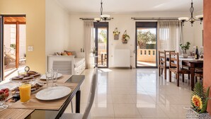 A spacious kitchen with a dining area, a balcony, and a view of the outdoors. - Villa Fanouris (Chania)