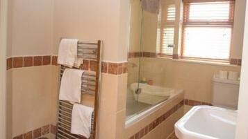 Un baño con una bañera, un lavamanos y un perchero para toallas.