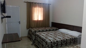 Un dormitorio con dos camas, un armario y una ventana con cortinas.