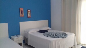 A hotel room with a single bed, a nightstand, and a blue accent wall. - Pousada Primavera da Serra (Serra Negra)