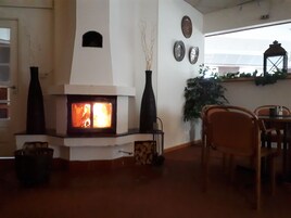 Um quarto aconchegante com lareira, uma mesa de jantar e cadeiras.