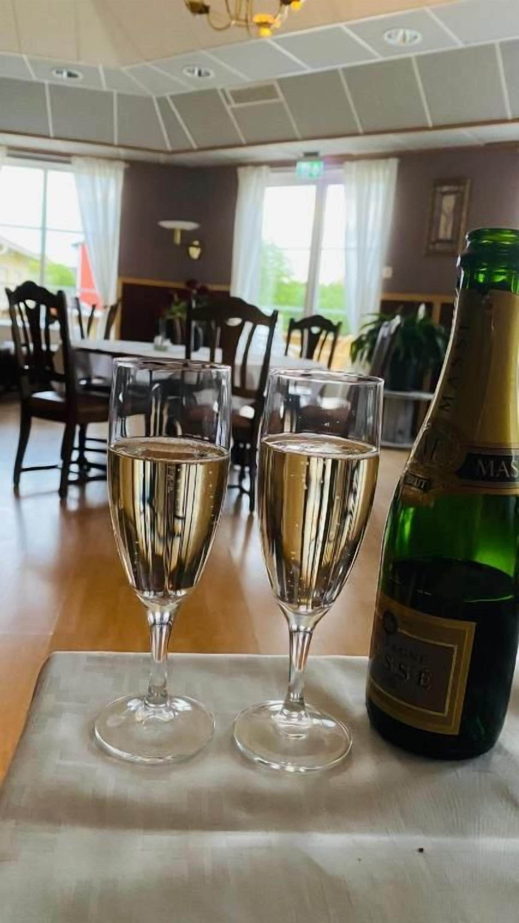 Två champagneglas på ett bord, med en flaska bredvid.