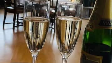 Två champagneglas på ett bord, med en flaska bredvid.