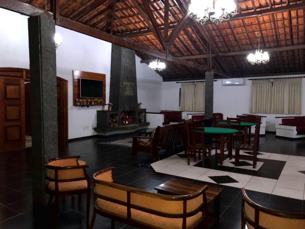 A spacious room with a high ceiling, a fireplace, and a billiards table.