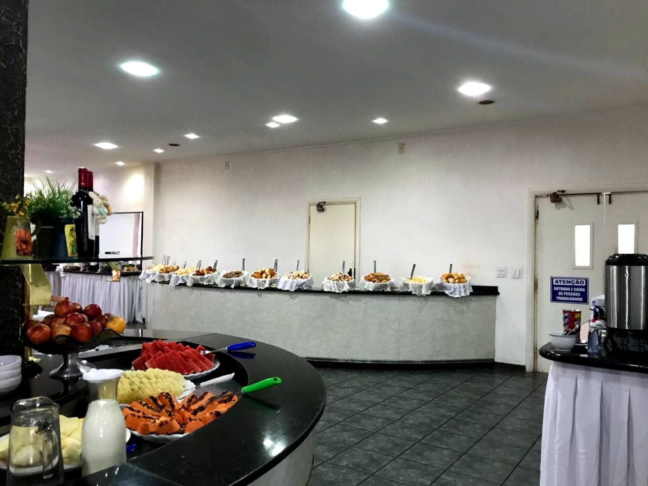 Disposição de buffet com diversos tipos de comida e um canto para café.