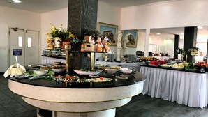 Montaje de bufé con varias estaciones de comida y un pilar decorativo central.