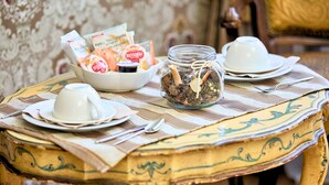 A breakfast table with a bowl of pastries, a jar with dried flowers, and tea cups. - Ai Cherubini (Venice)