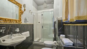 A bathroom with a large mirror, a sink, a toilet, and a glass-enclosed shower. - Ai Cherubini (Venice)