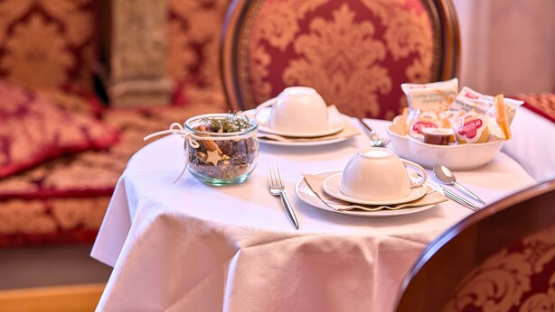 A table set with white tableware and a bowl of fruit. - Ai Cherubini (Venice)