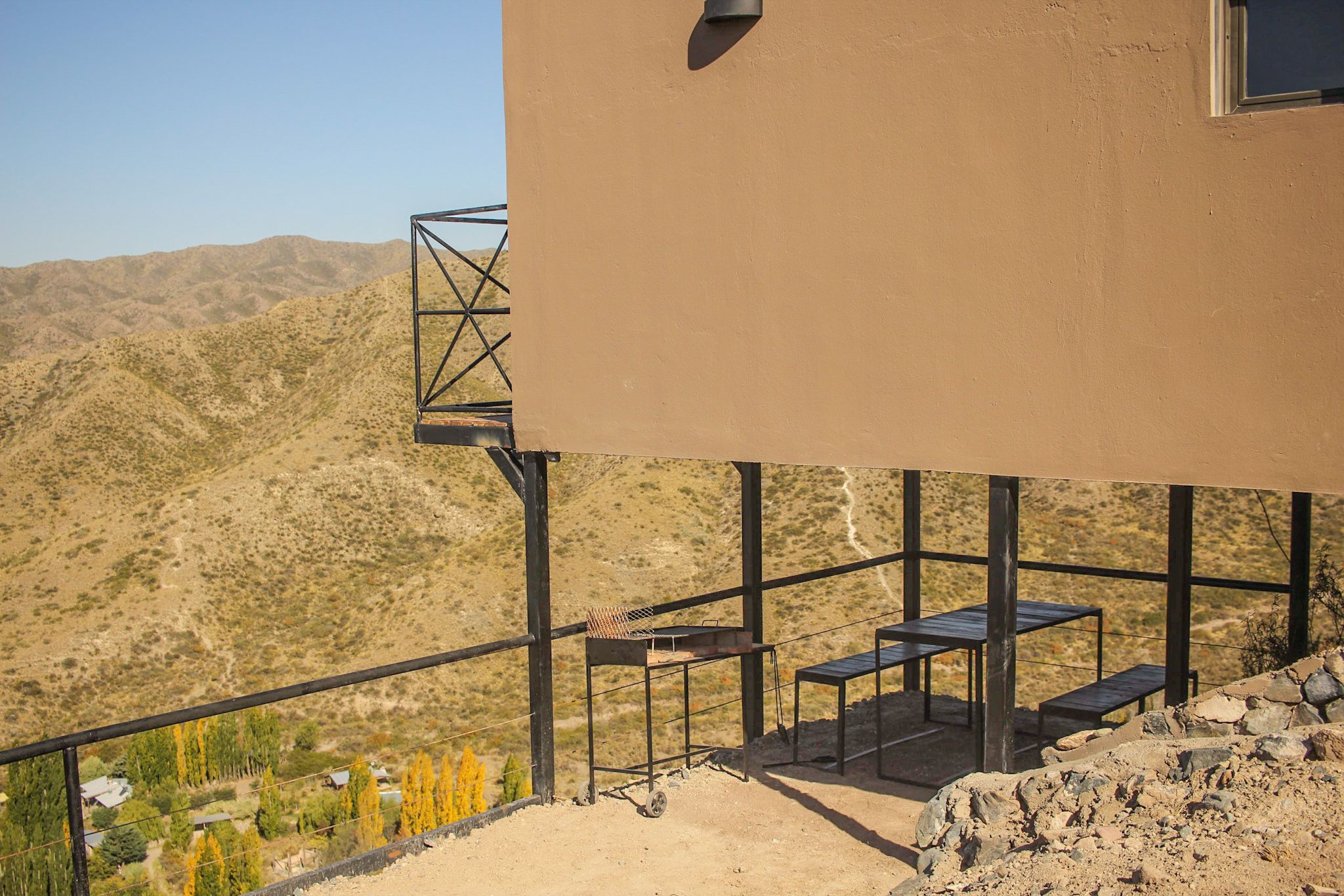 A modern building with a balcony overlooking a mountainous landscape.
