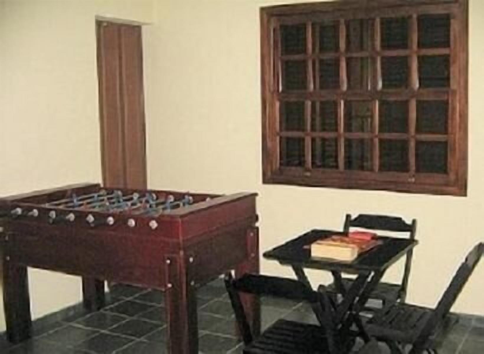 A room with a foosball table, a window, and a small table with chairs.
