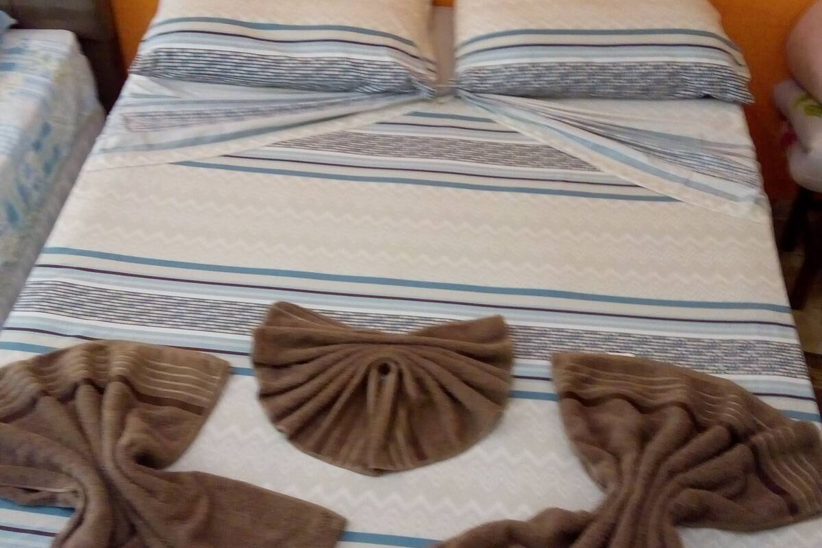 Ein Bett mit gestreifter Bettwäsche und dekorativen Kissen.