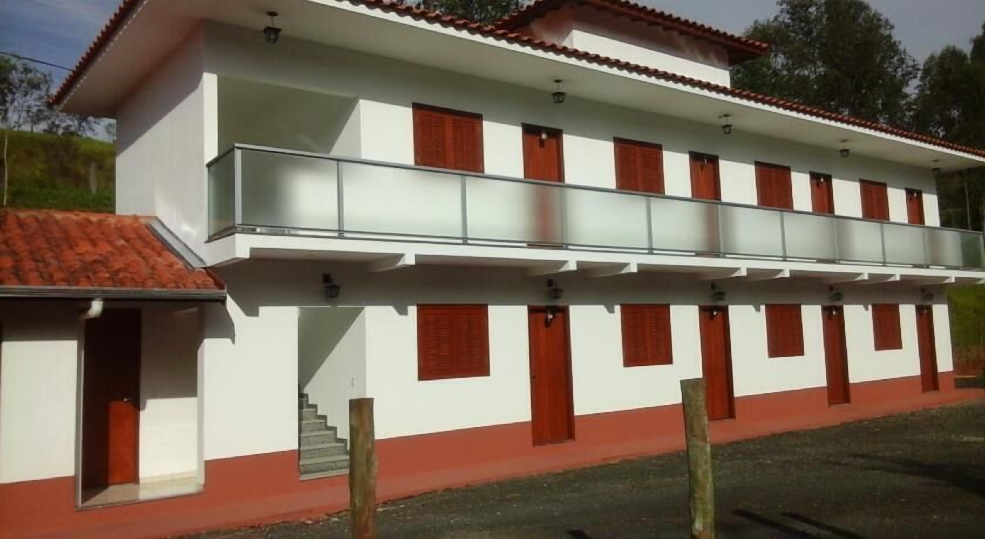 Een gebouw met twee verdiepingen, met een balkon op de bovenste etage.