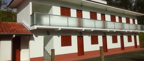 Een gebouw met twee verdiepingen, met een balkon op de bovenste etage.