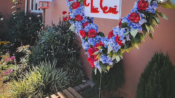 A building with a heart-shaped floral decoration and a sign that reads "PUESTADA Tiga Cari". - Pousada Tia Eni (Gramado)