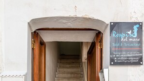 A staircase leading to a room with a sign advertising bed and breakfast services. - Respiro del Mare (Polignano a Mare)