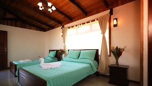 A hotel room with two beds, wooden ceiling beams, a nightstand with a vase of flowers, and a wall-mounted light. - Maris B&B (Monteverde)