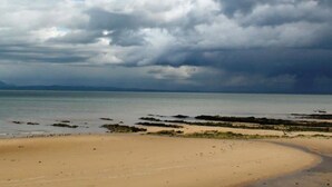 A beach with a sandy shore and rocky outcrops. - Powillimount Cottage (Dumfries)
