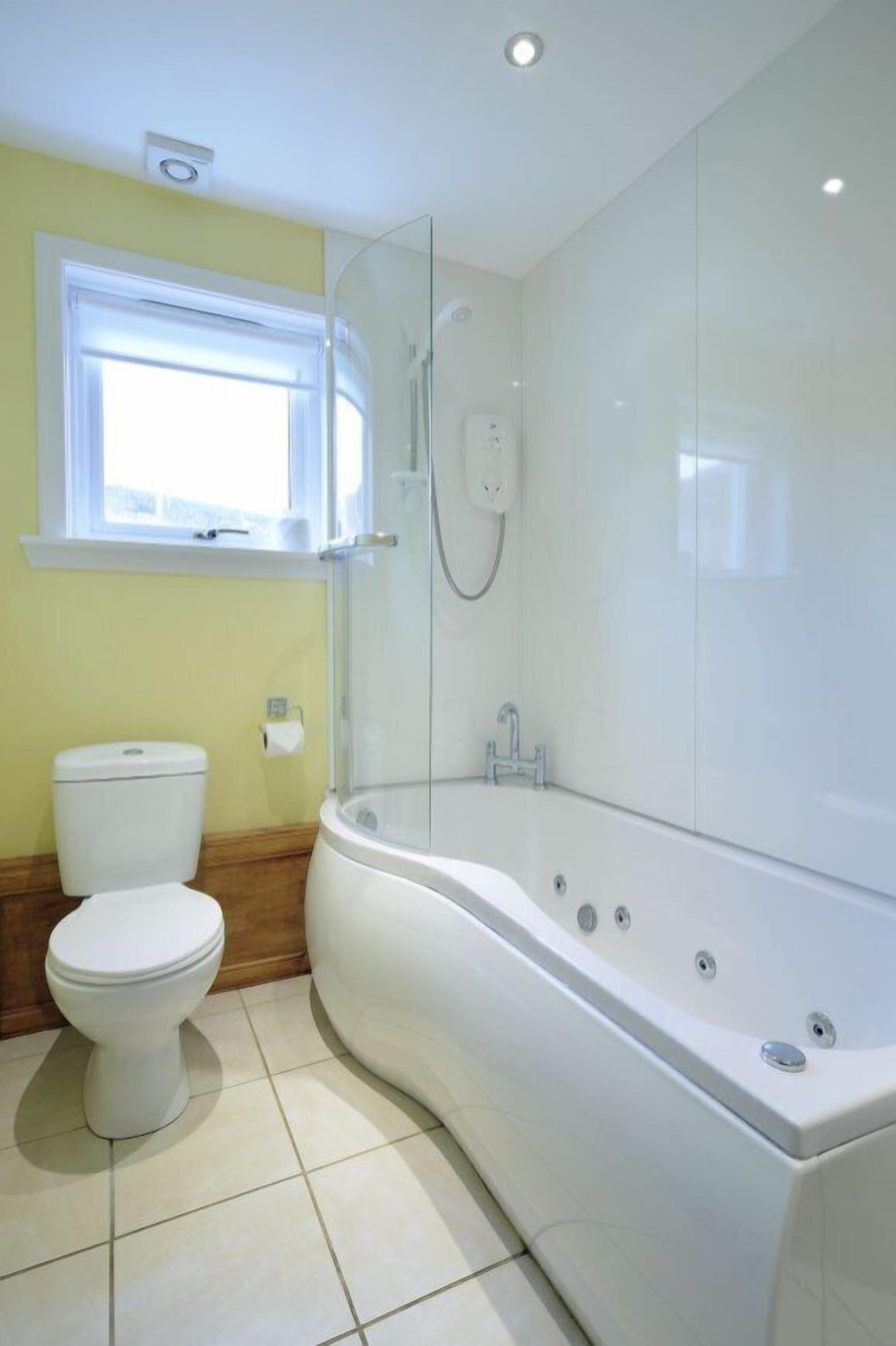 A bathroom with a toilet, a bathtub, and a glass shower enclosure.