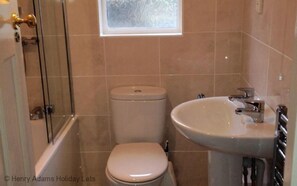A bathroom with a toilet, a sink, and a shower area. - Surima, Chichester 48663 (Chichester)