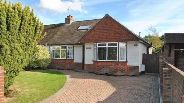 A single-story house with a brick facade, a tiled roof, and a paved driveway. - Surima, Chichester 48663 (Chichester)