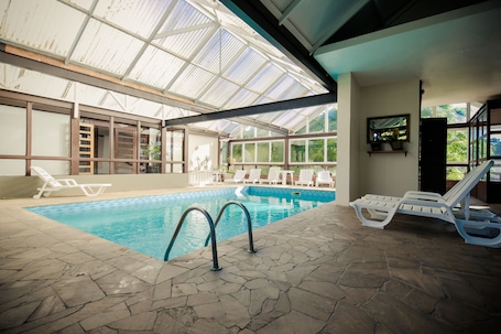 Indoor pool, pool loungers. Grande Hotel Canela