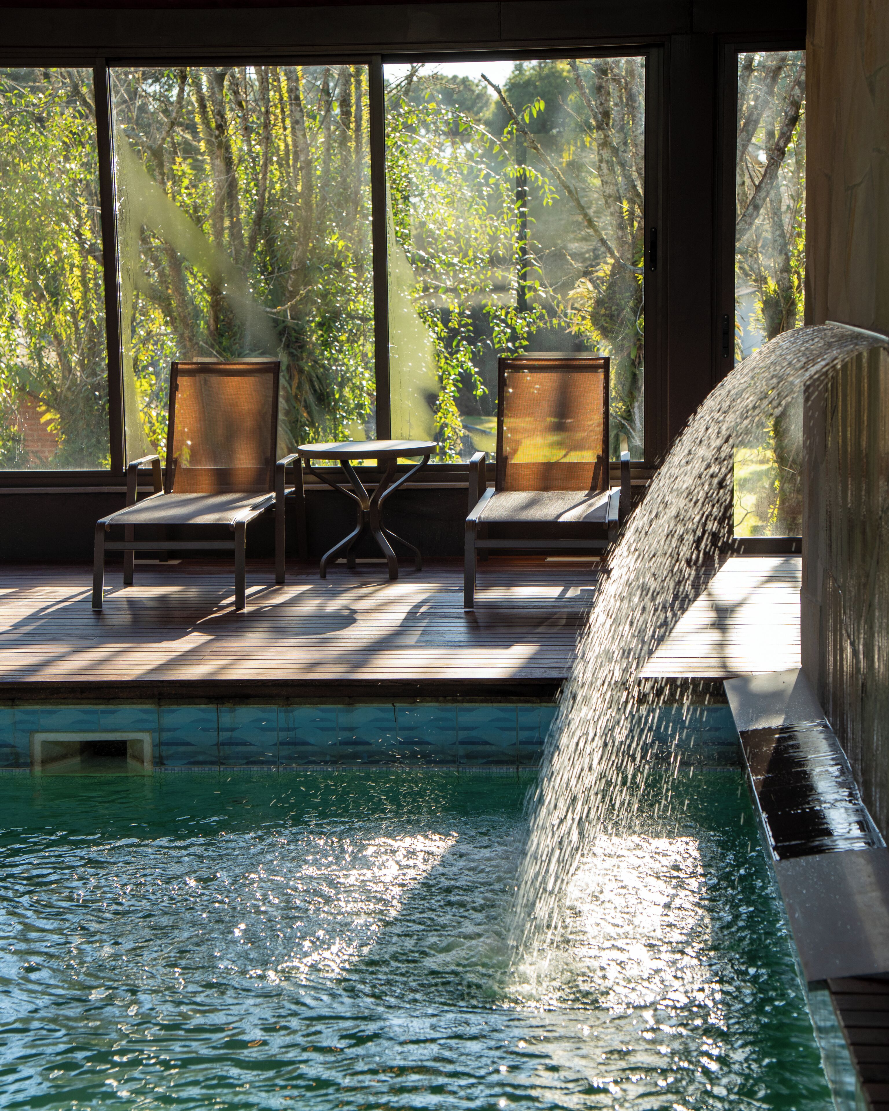 Una piscina techada, sillones reclinables de piscina