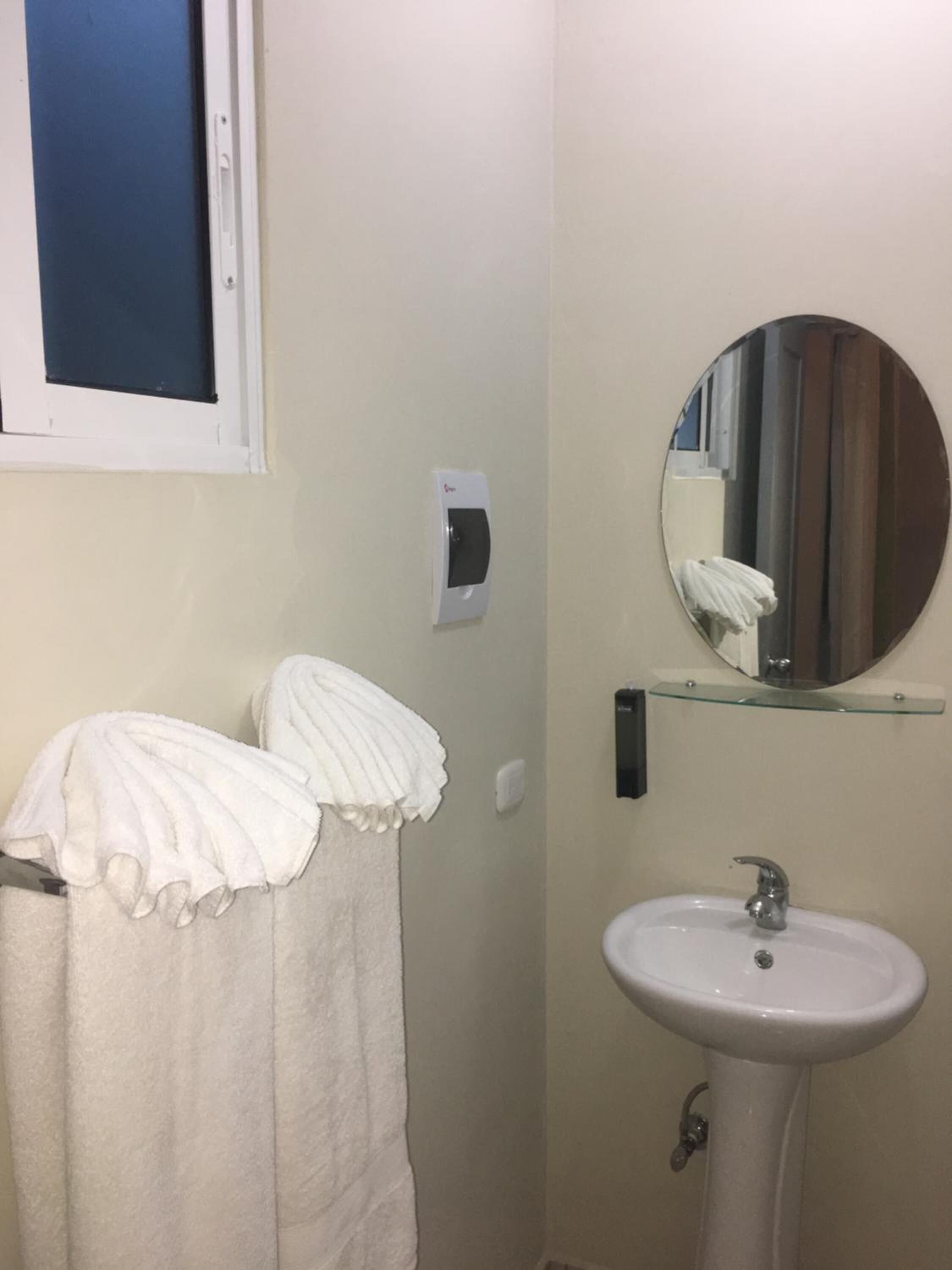 Une salle de bain avec un lavabo, un miroir et des serviettes.