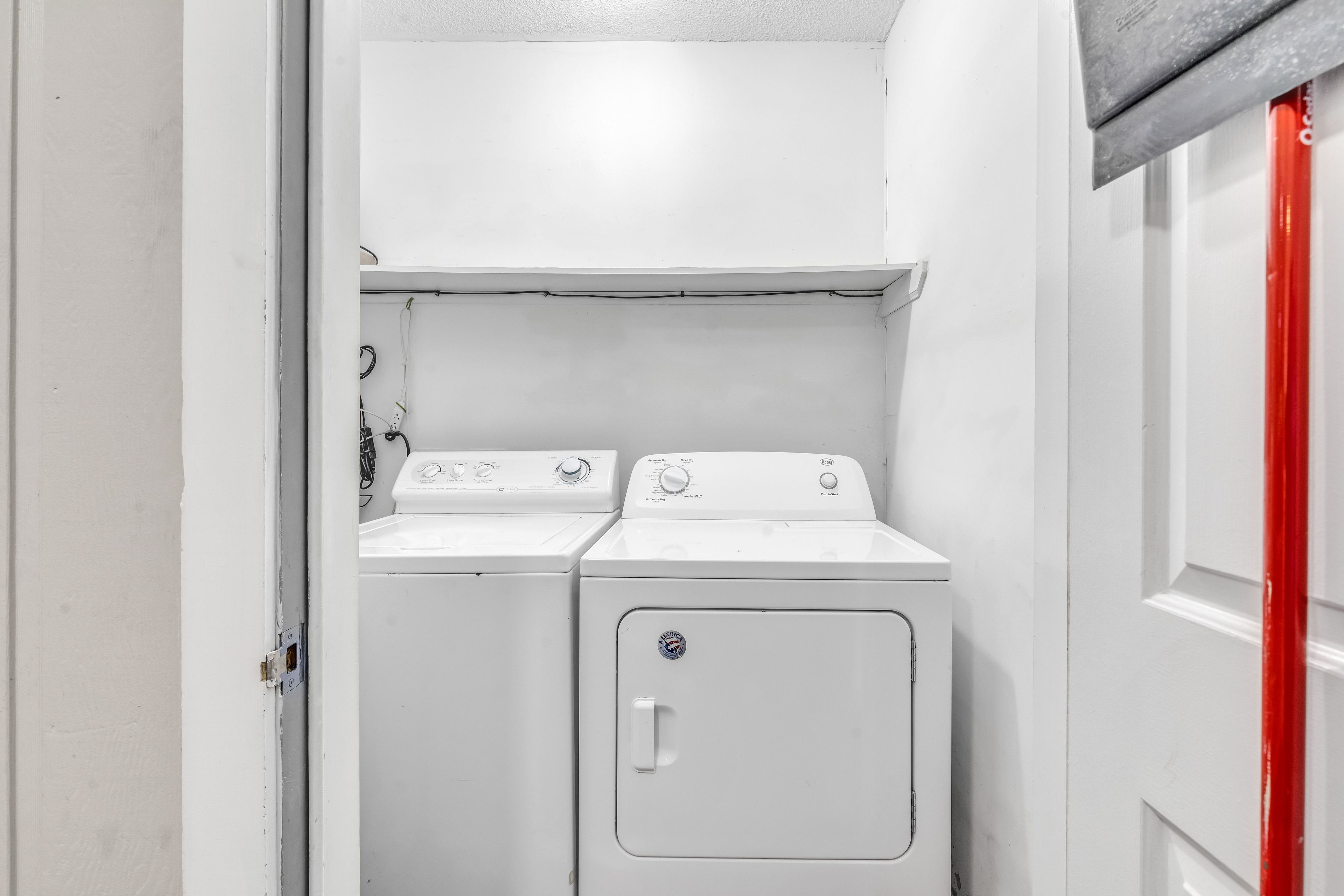 A laundry room with two stacked washing machines and a dryer.
