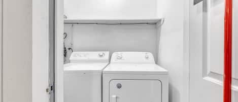 A laundry room with two stacked washing machines and a dryer.
