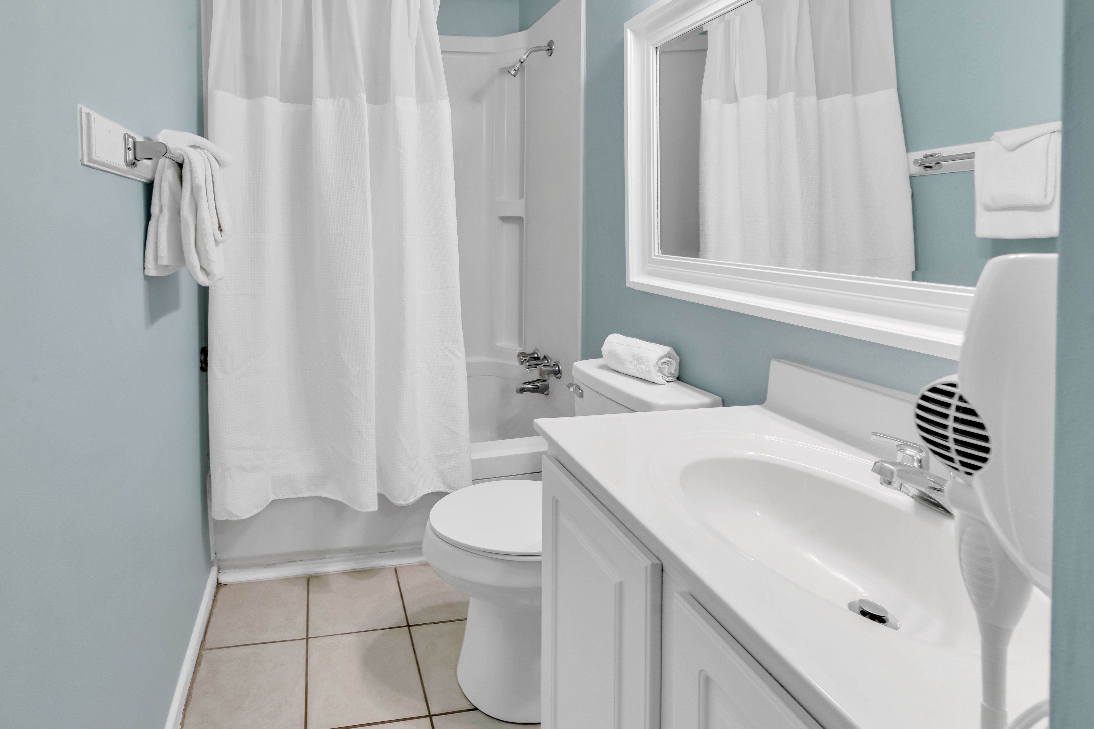 A bathroom with a toilet, sink, and shower area.